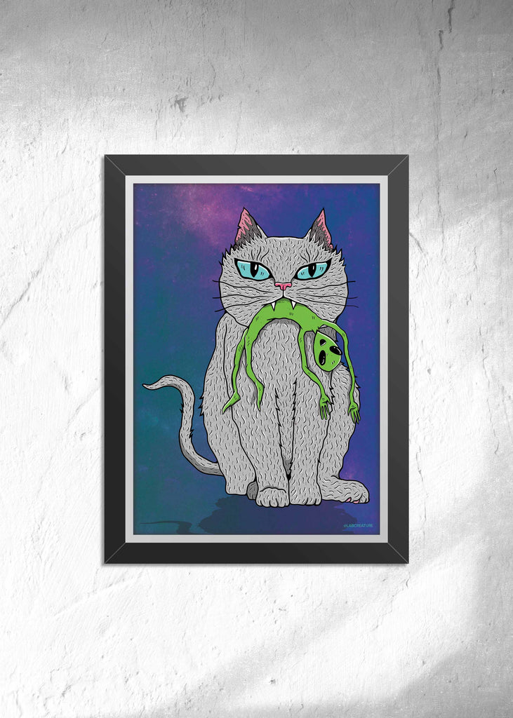 Framed art of a grey cat holding a small green alien in it's mouth on a blue and purple background