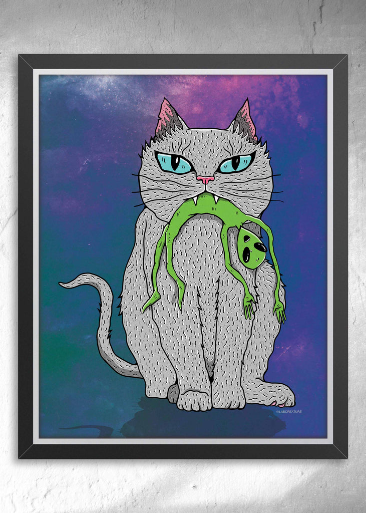 Framed art of a grey cat holding a small green alien in it's mouth on a blue and purple background