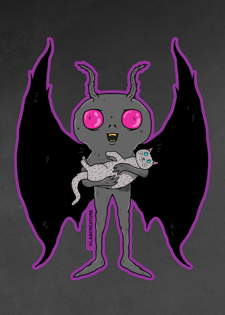 Photo of a vinyl sticker featuring an illustration of Mothman holding a cute white cat.